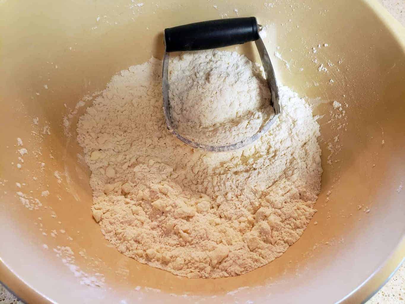 butter cut into flour mixture in bowl with pastry cutter