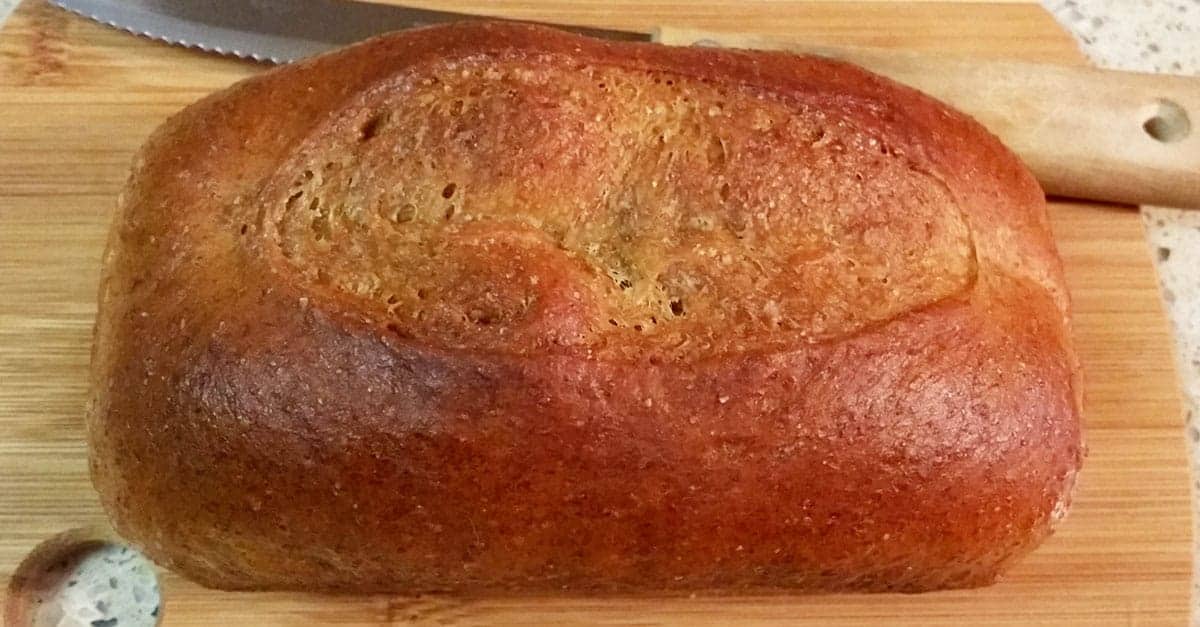Finished moni loaf od Honey Whole Wheat Bread on wooden cutting board