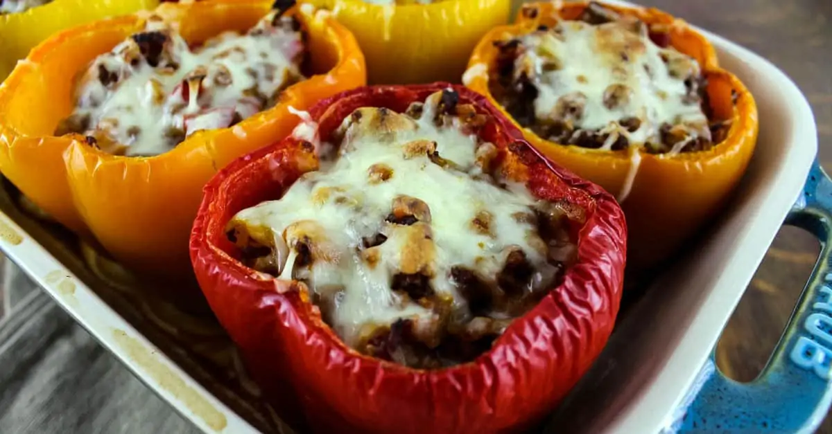 Red, yellow, and orange Baked Stuffed Bell Peppers in baking dish