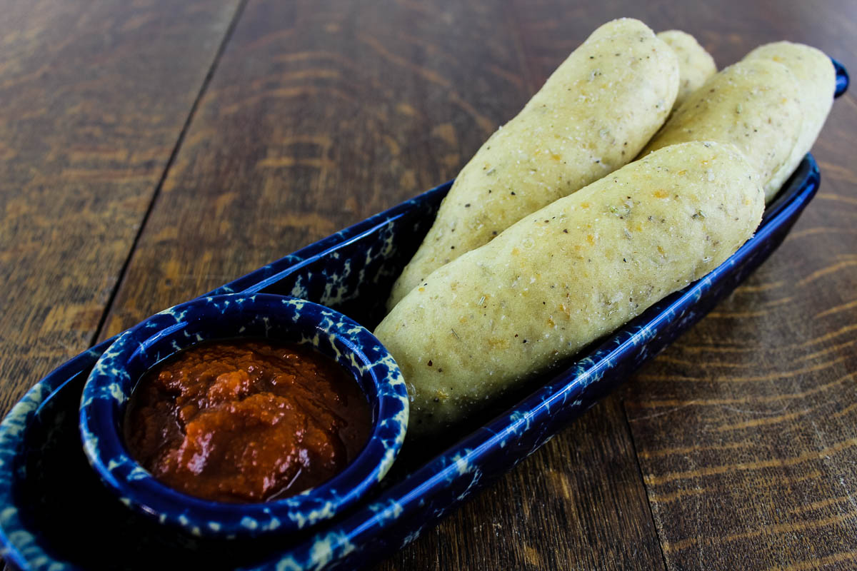 Parmesan Rosemary Breadsticks in blue bowl with Marinara Sauce