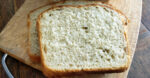 sliced sourdough honey oat bread on wooden cutting board